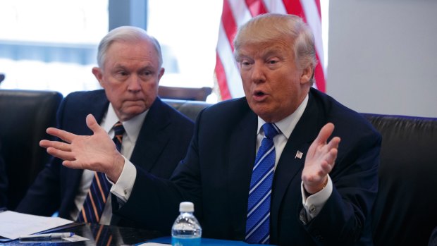 Senator Jeff Sessions looks on as Republican presidential candidate Donald Trump speaks during a 'national security meeting' with advisors at Trump Tower on Friday.