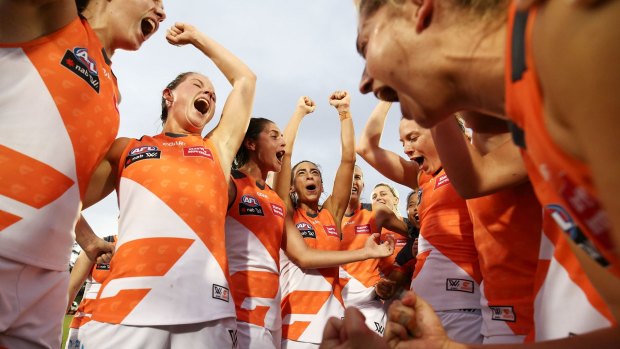Hard-earned: Giants players celebrate victory following their breakthrough AFLW victory, over the Demons at Blacktown.