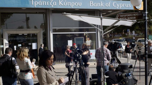 The run that never happened ... Camera crews wait in vain for signs of panic outside a Bank of Cyprus branch in Nicosia.