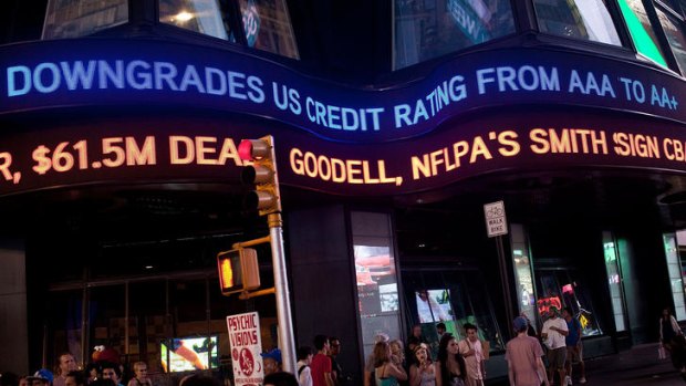 "Standard & Poor's downgrades US credit rating from AAA to AA+" in Times Square.