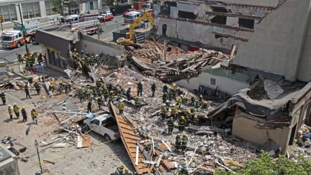 Rescue personnel search the scene of a building collapse in downtown Philadelphia. Rescue crews were trying to extricate the two people who were trapped, city Fire Commissioner Lloyd Ayers said.