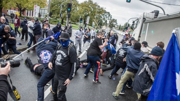 Protesters from rival groups, many wearing masks or balaclavas, fight each other in Coburg.