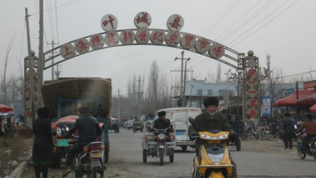A sign above a road in Xinjiang's Kargilik county publicises investment in the area from Shanghai.