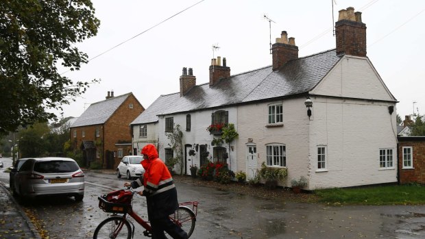 A postal worker delivers letters in the village where Brenda Leyland lived, at Burton Overy in central England October 6, 2014