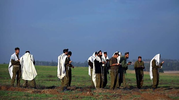 Tenuous truce &#8230; Israeli soldiers pray at an artillery emplacement close to the border with Gaza. Israel seemed to bet the ceasefire might inject goodwill into its shaky alliance with Egypt.