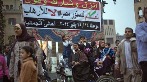 Stark choice: Egyptians pass a banner in Cairo on Monday urging them to vote "yes to Egypt's constitution and no to terrorism". 