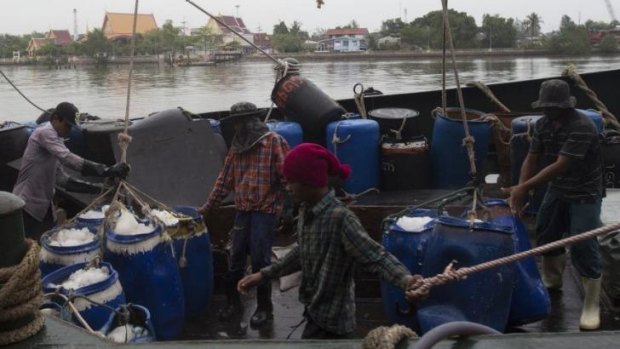 Migrant workers unload frozen fish from a boat at a fish market in Samut Sakhon Province, west of Bangkok.