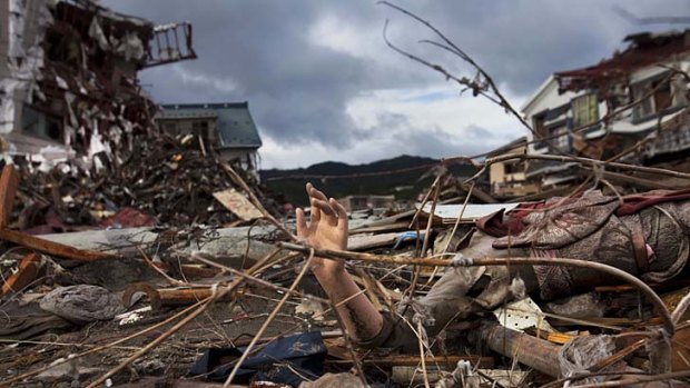 A mannequin's arm sticks out from the rubble in a devastated neighbourhood of Kesennuma, Miyagi prefecture.