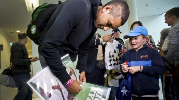 Nick Kyrgios signs a poster for young fan Charlie Camus, 7.