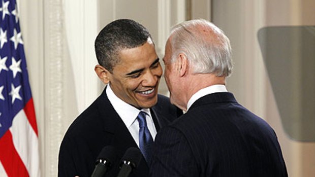 U.S. Vice President Joe Biden, right, whispers a remark to President Barack Obama that contained an expletive, which was picked up by TV microphones.