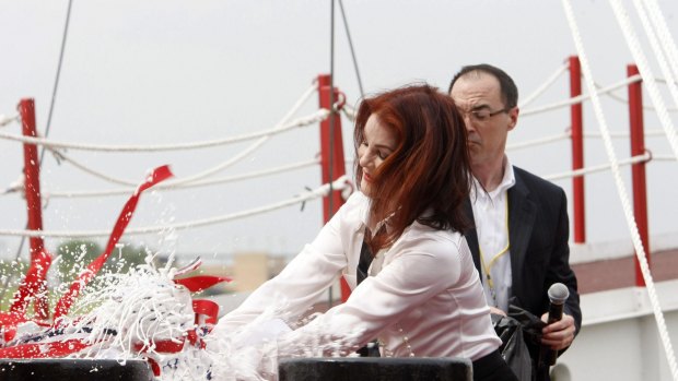 Priscilla Presley smashes a bottle of champagne on the American Queen as she re-christens the refurbished river cruise liner.