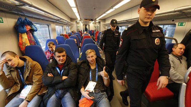 Police officers patrol a train at the train station in the Adler district of Sochi.