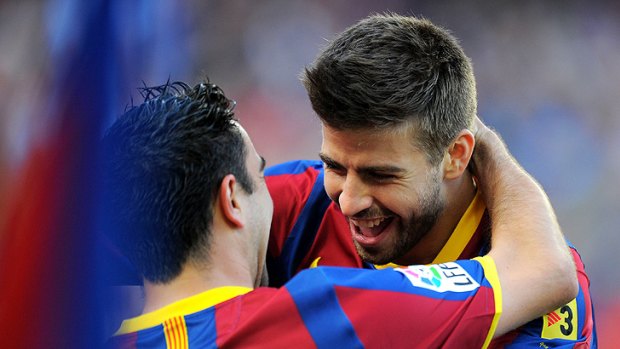 Barcelona's Gerard Pique (right) celebrates with teammate Xavi Hernandez after scoring in his team's 2-0 win over Espanyol.