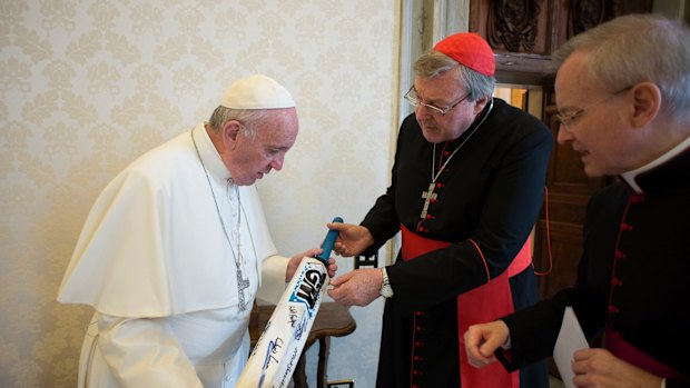 Pope Francis receives a cricket bat from Cardinal George Pell at the Vatican in 2015.