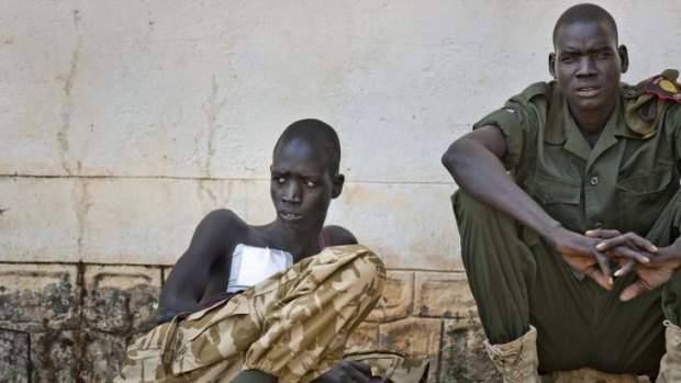 A wounded soldier sits with a colleague in an outside courtyard at the Juba Military Hospital.