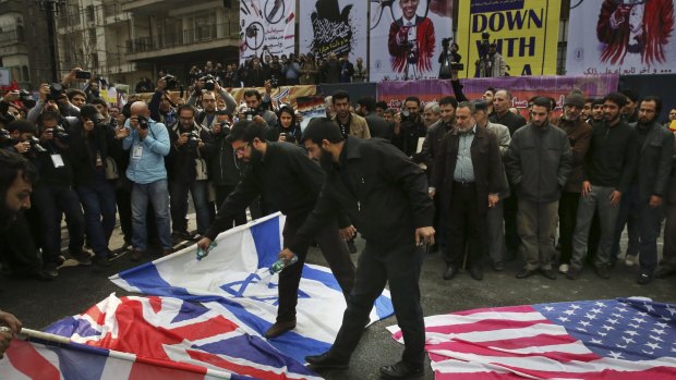Iranian demonstrators pour petrol on the US, British and Israeli flags at a rally  in Tehran last month. 