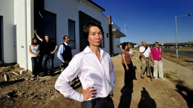 Tanya Nguyen, of Wright, and other affected home buyers from across Canberra gather outside her unfinished house; from back left, Bethany and James Liddall, Subhash Rewal, Thuy Ha and her sister Thi Ha, and Lorraine and David Anderson.
