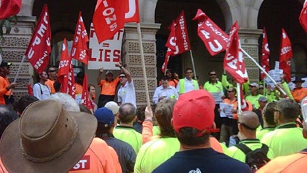 Postal workers protest outside an Australia Post outlet in Brisbane yesterday.