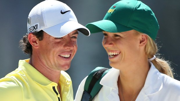 Caroline Wozniacki caddying for McIlroy during the Par 3 Contest prior to the start of the 2013 Masters Tournament.