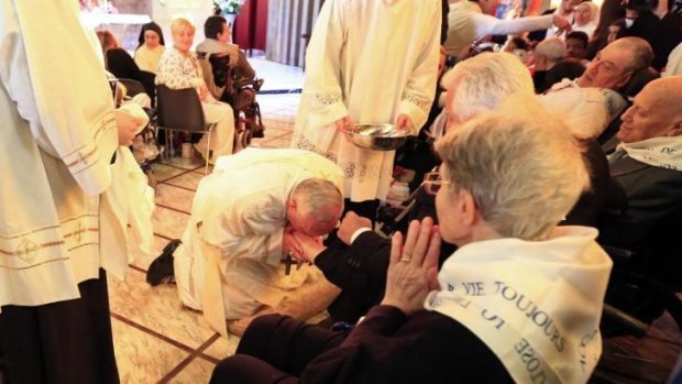 Pope Francis kisses the foot of a disabled person at the Santa Maria della Provvidenza church in Rome during the Holy Thursday celebration.