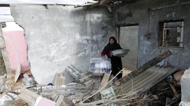 A Palestinian woman surveys the destruction to her house in Gaza following an Israeli airstrike.