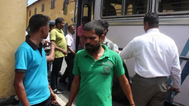 An asylum seeker is delivered to court at Galle by Sri Lankan navy personnel.