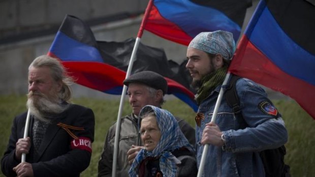 Flying the flag: Pro-Russian activists hold the Donetsk republic flag during celebrations of the Victory Day at a WWII memorial.