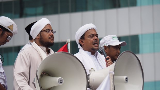 Rizieq Shihab (with microphone) speaks in Jakarta in January. His role in the blasphemy trial of Ahok has been criticised.
