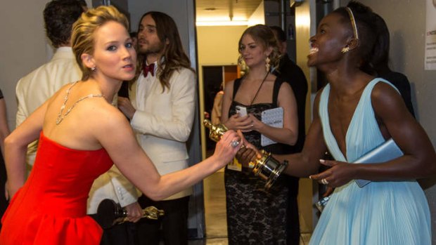 Best supporting actress nominee Jennifer Lawrence wrestles in jest with winner Lupita Nyong'o for her Oscar.