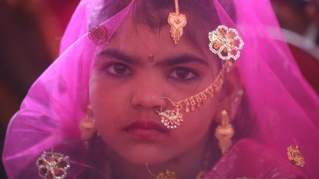 A veiled girl from the Gujarat region of India waits for her engagement ceremony to start. 