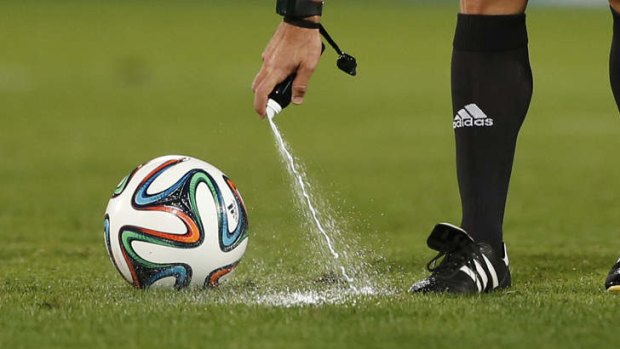 A referee marks a line with a temporary spray during a match between Raja Casablanca and Atletico Mineiro at the Club World Cup soccer tournament in Marrakech.