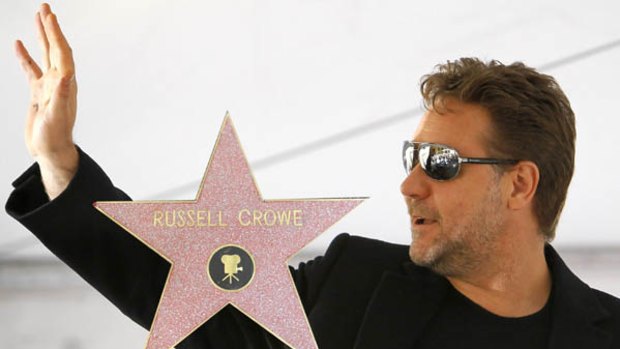 Actor Russell Crowe waves at fans during the ceremony and (inset) his star.