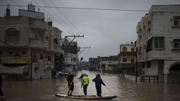 Deep water: Palestinian rescue members evacuate residents using fishing boats following heavy rains in Gaza City on Saturday.