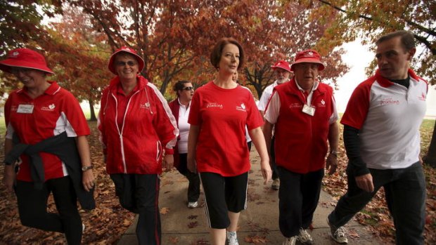 Prime Minister Julia Gillard and members of the Heart Foundation Walking Group walk around Lake Burley Griffin in Canberra yesterday, the same day changes to the aged care system were announced.