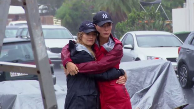 House Rules competitors Ella and Kate embrace after the competition is suspended on the Gold Coast due to safety concerns.