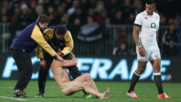 The streaker is manhandled at the All Blacks Test in Dunedin on Saturday.