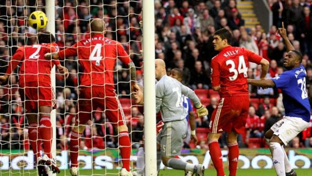 Sylvain Distin of Everton (not pictured) scores his team's first goal against Liverpool.