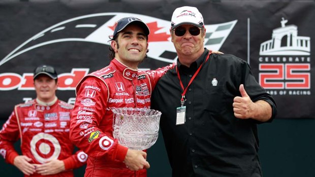 Dario Franchitti   is presented with the trophy by actor Dan Ackroyd.