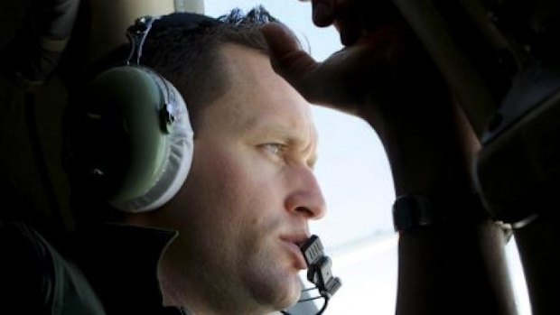 More debris located ... a crew member of an Royal Australian Air Force AP-3C Orion patrol plane, looks out of his observation window.