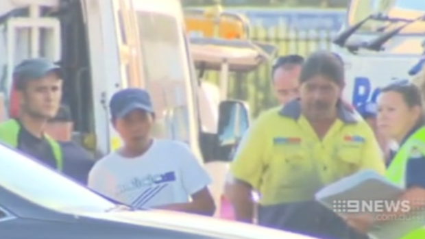 Seksane, left, and another hostage leaves the factory at Ingleburn where they were trapped. 