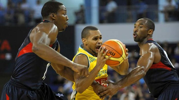 Patrick Mills (C) of Australia vies with Kobe Bryant (R) and Dwight Howard of the US.