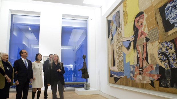 Maya Picasso, left, the daughter of Spanish artist Pablo Picasso, French President Francois Hollande, listen as chief curator of the Musee National Picasso, Anne Baldassari, right, speaks about <em>Women in The Bathroom</em> during the inaugural exhibition of the Picasso Museum in Paris.