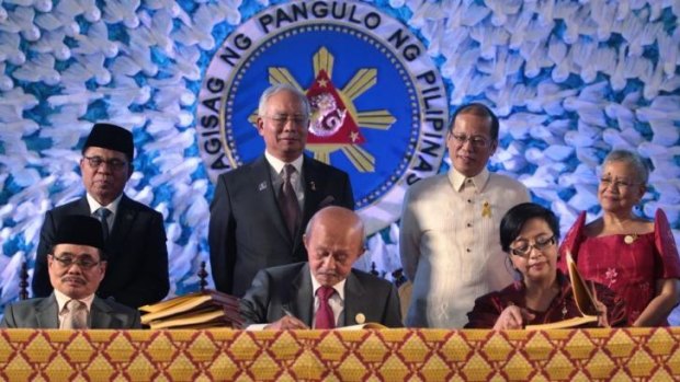 Malaysian Prime Minister Najib Razak and Philippines President Benigno Aquino witness the signing of the peace pact.