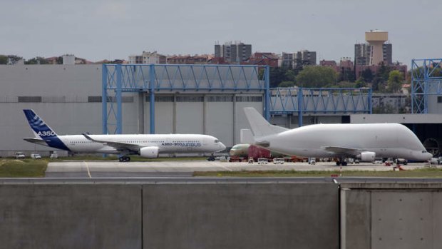 The new Airbus A350 XWB aircraft built by Airbus, left, passes an Airbus Beluga super transporter aircraft as it returns to its base after leaving the paint hanger at the plant in Toulouse.