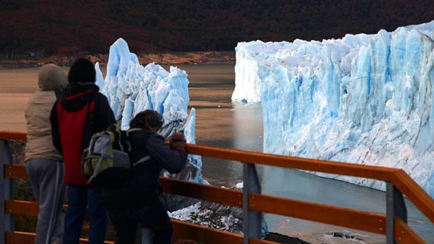 Tourists look at the Perito Moreno glacier after the rupture of a massive ice wall.