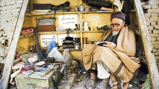 A long and dusty road ahead...an Afghan shoe polisher takes a break and reads a book in Kabul