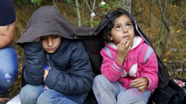 Children of Syrian migrants shelter from the rain near Asotthalom, Hungary.