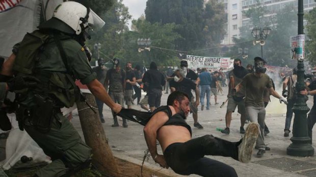 Protestors clash with riot police during a large anti-austerity demonstration in Athens last year.