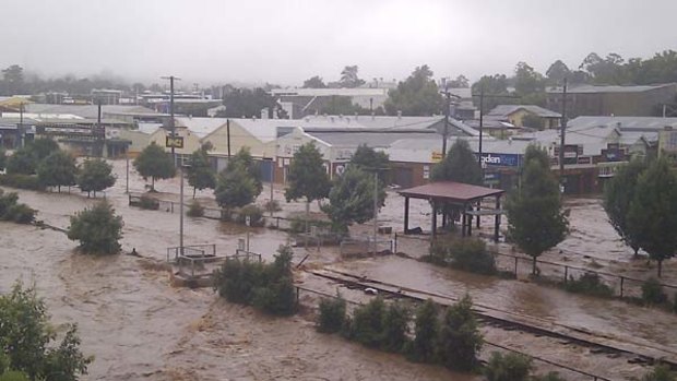 Wild scenes ... water pours through Toowoomba yesterday, picking up cars as if they were toys and inundating businesses.