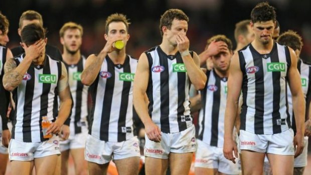 The Magpies leave the field after losing to Essendon.